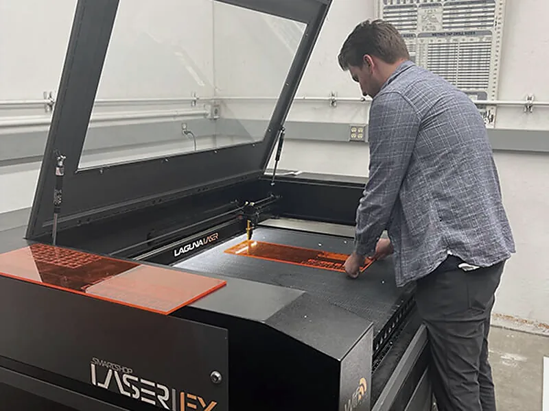 Operador trabalhando em uma máquina fechada de corte a laser CO2