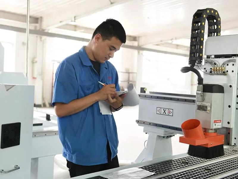 فني يفحص ماكينة راوتر CNC بجوار الماكينة